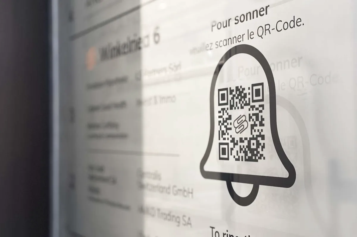 Enseigne QR-Bell à l'entrée d'un immeuble : le QR-Code en forme de cloche à scanner pour sonner